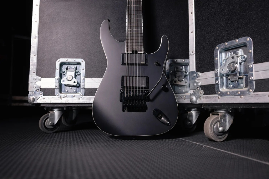 Jackson Pro Series Signature Chris Rörland SL7 Soloist junto a flightcases