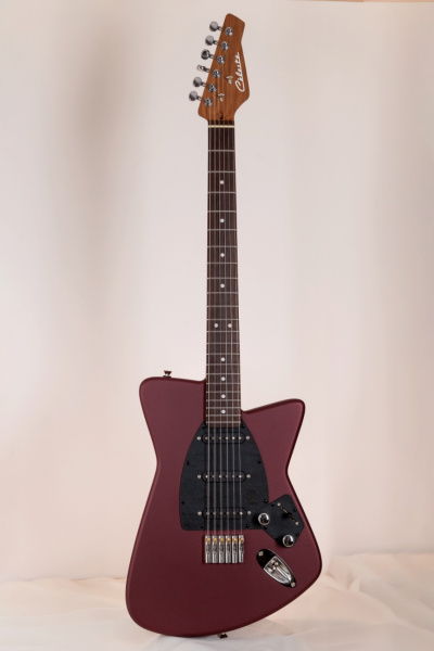 Guitarra eléctrica entera de frente con acabado Bordeaux Kuro mate, mástil de arce tostado y seis clavijas en línea.