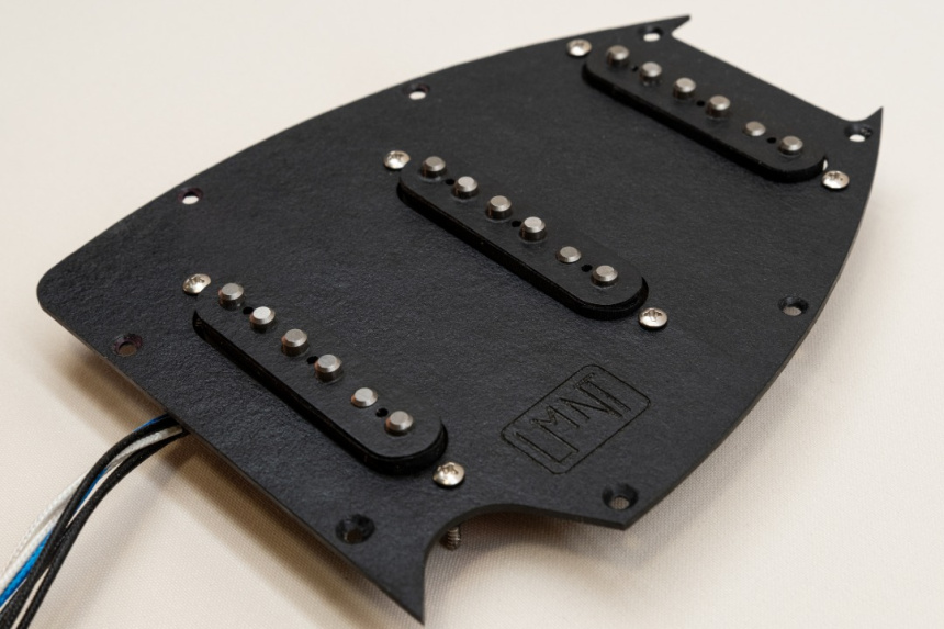Módulo SSS fuera de la guitarra con golpeador negro, tres pastillas y cables a la vista.