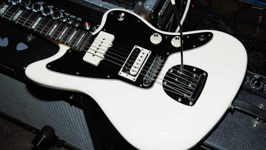 Primer plano del cuerpo de la Fender Kim Gordon Jazzmaster tumbada sobre un amplificador mostrando sus pastillas y palanca de trémolo