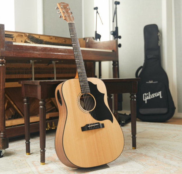 Gibson G-Bird junto a piano