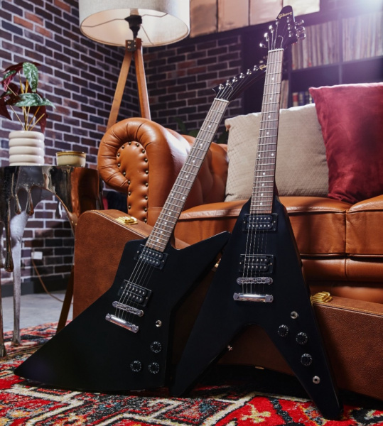 Gibson 80s Flying V y Explorer Ebony junto a sofá