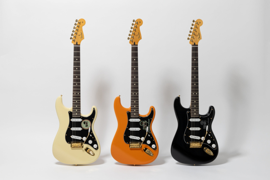 Tres guitarras Stratocaster de pie sobre fondo blanco con acabados Olympic White, Orange y Black