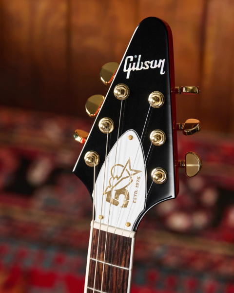 Primer plano de la pala negra con logo Gibson y tapa del alma blanca con el logotipo dorado de los 50 años.