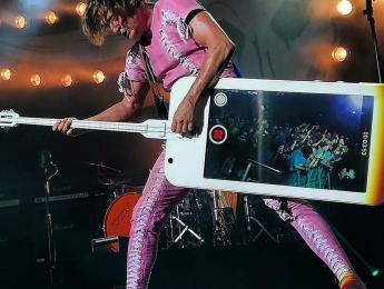 Stig Pedersen y su bajo con forma de iPhone que hace fotos al publico