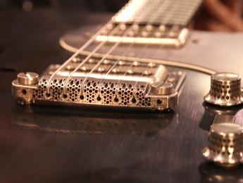 Un puente de guitarra impreso en 3D con metal amorfo diseñado por el luthier Nik Huber